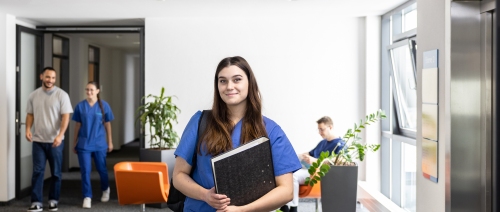 Header Ausbildung  Auszubildende mit Aktenordner im Arm